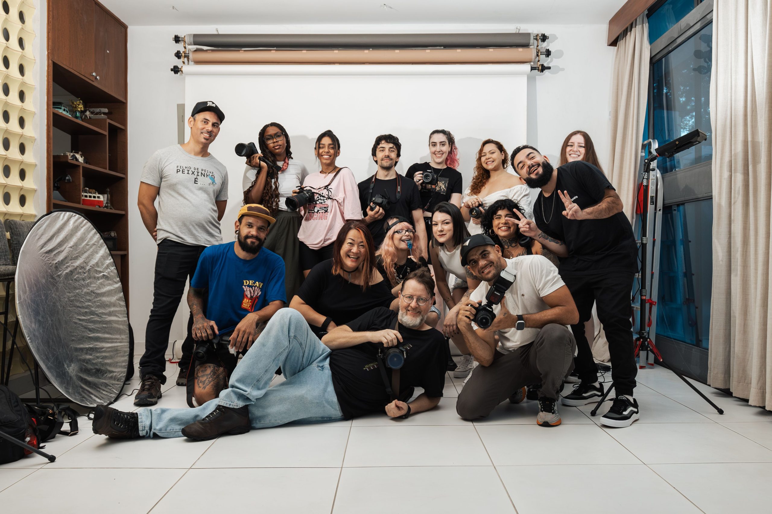 Cheerful group of photographers posing together in a bright photography studio.